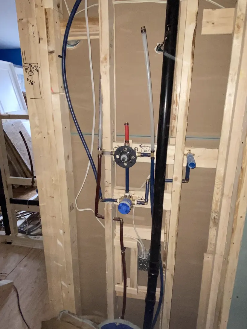 Robinetterie de douche installée dans la charpente avant la fermeture du mur